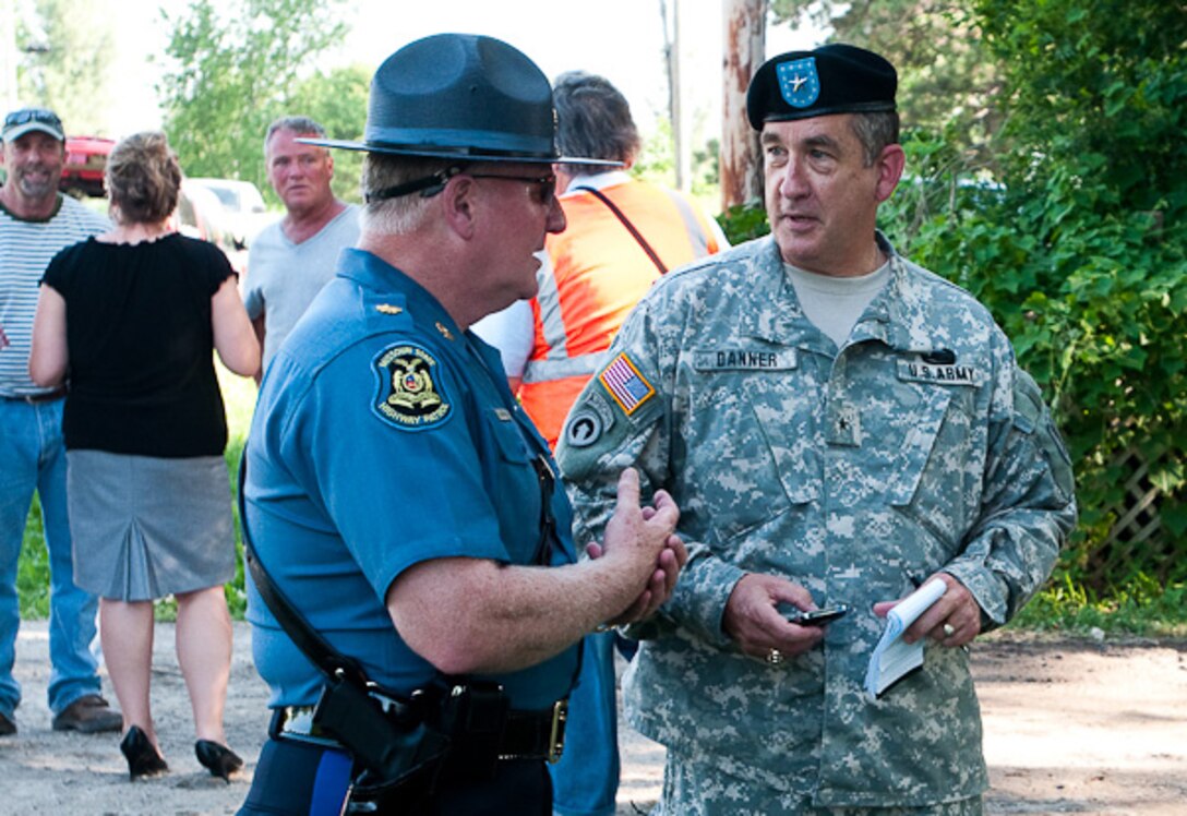 U.S. Army Brig. Gen. Stephen Danner, right, Missouri adjutant general, visits with a Missouri Highway Patrolman in Fortescue, Mo., June 22, 2010, as flood waters spread and threaten the town. Missouri Gov. Jay Nixon was accompanied by Danner; Air Force Col. Mike McEnulty, commander of the 139th Airlift Wing and area journalists as he visited the community and surveyed the damage.