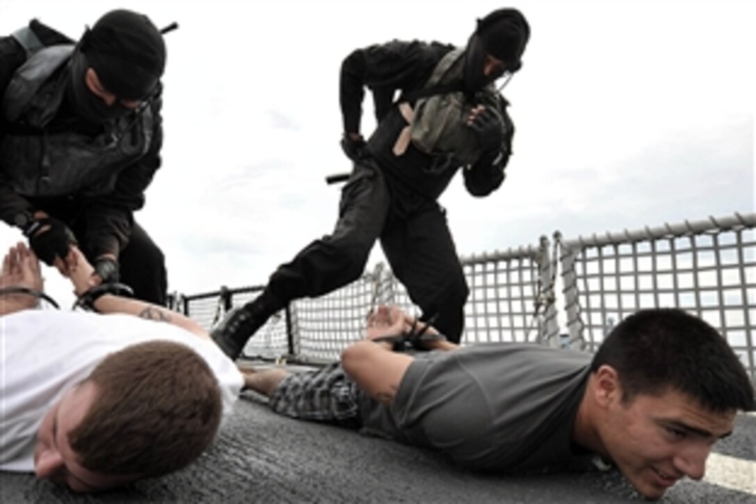 Royal Malaysian Navy sailors search and flex-cuff mock suspects during a boarding exercise on the U.S. Coast Guard Cutter Mellon in the Andaman Sea, June 23, 2010. The exercise was part of Southeast Asia Cooperation Against Terrorism 2010. 