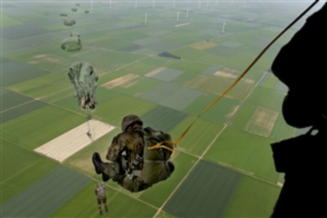 U.S. Army soldiers, airmen, and Marines as well as soldiers from five NATO nations, parachute from a C-130J Hercules aircraft over the Alzey drop zone in southwestern Germany, June 15, 2010. The soldiers, airmen and Marines, as well as soldiers from Belgium, Germany, Great Britain,Hungary, Norway and the Netherlands, participated in airborne operations during International Jump Week 2010.