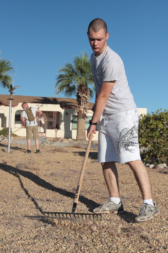 Private First Class Kahlan Sword, a traffic management specialist with Company B., Headquarters Battalion, works on the front yard of two local women Saturday morning. The sisters were overjoyed to have Marines from the Combat Center come out and help them with the overdue yard work.