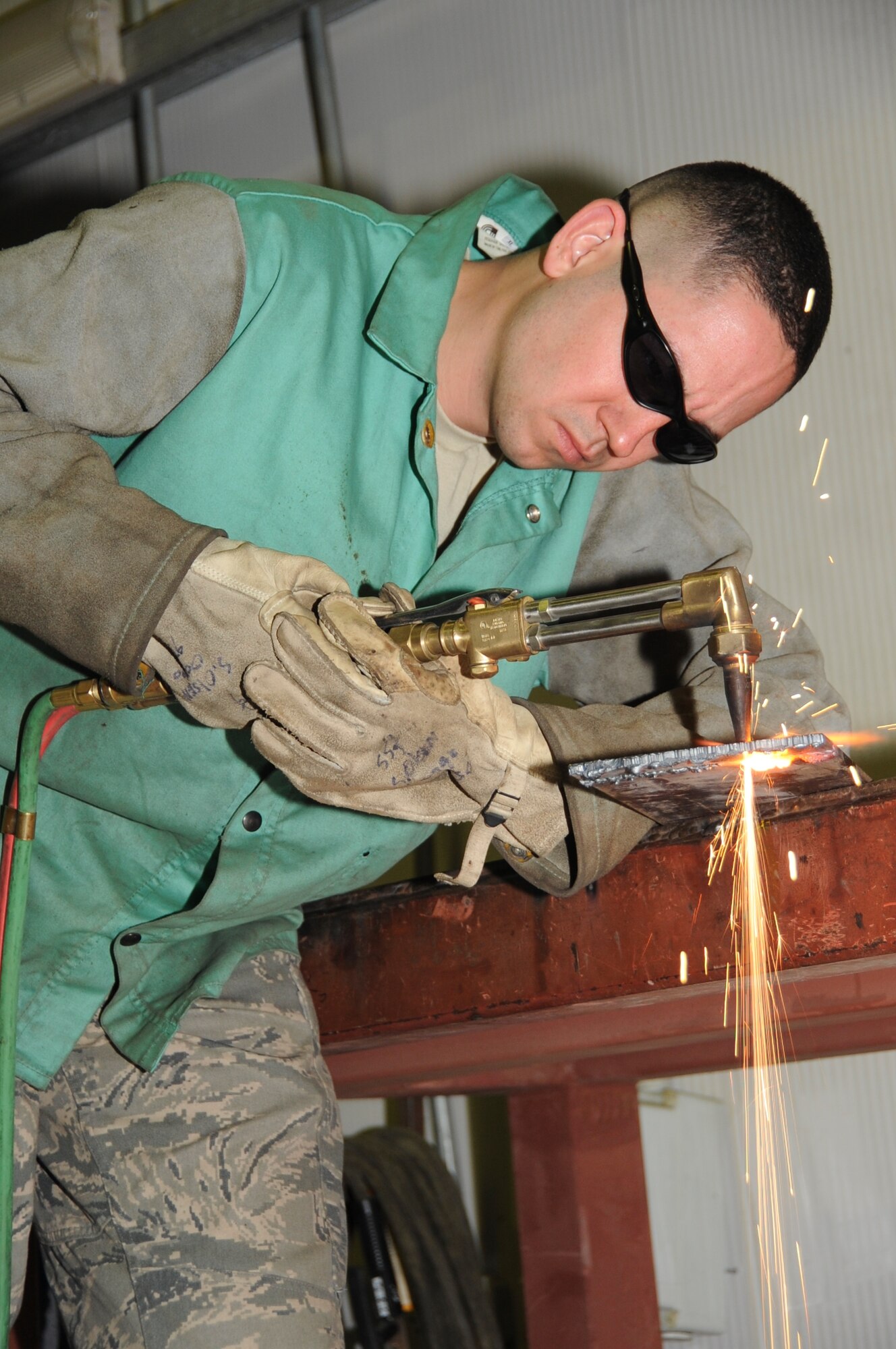 Staff Sgt. Sam Olsen, 380th Expeditionary Maintenance Squadron aircraft metals technician, cuts a piece of medal using an oxyacetylene cutting rig June 25 at an undisclosed location is Southwest Asia. (U.S. Air Force photo/Tech. Sgt April Wickes)