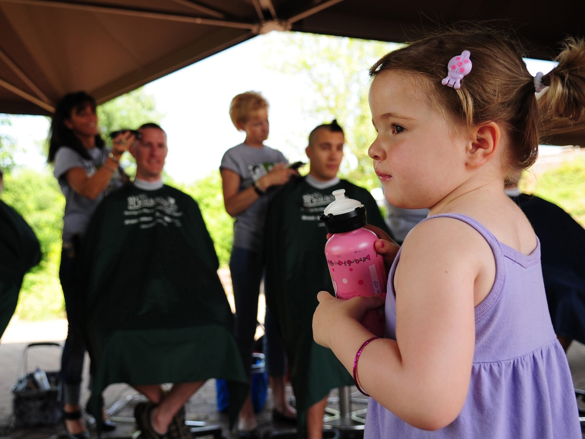 Josephine "Josie" Beardsley, 3, stands in wait as her father, U.S. Air Force Tech. Sgt. Timothy Beardsley 86th Maintenance Squadron, has his head shaved in participation of the St. Baldrick's event that he and his wife Heike organized in Josie's honor. Josie was diagnosed with Leukemia two years ago, Ramstein Air Base Germany, June 26, 2010. The St. Baldrick's Foundation is an organization that tasks volunteers with getting sponsored to have their heads shaved as a demonstration of their camaraderie to children that have been diagnosed with cancer. This is the 1st ever St. Baldrick's event held on Ramstein AB. (U.S. Air Force photo by Staff Sgt. Jocelyn Rich)