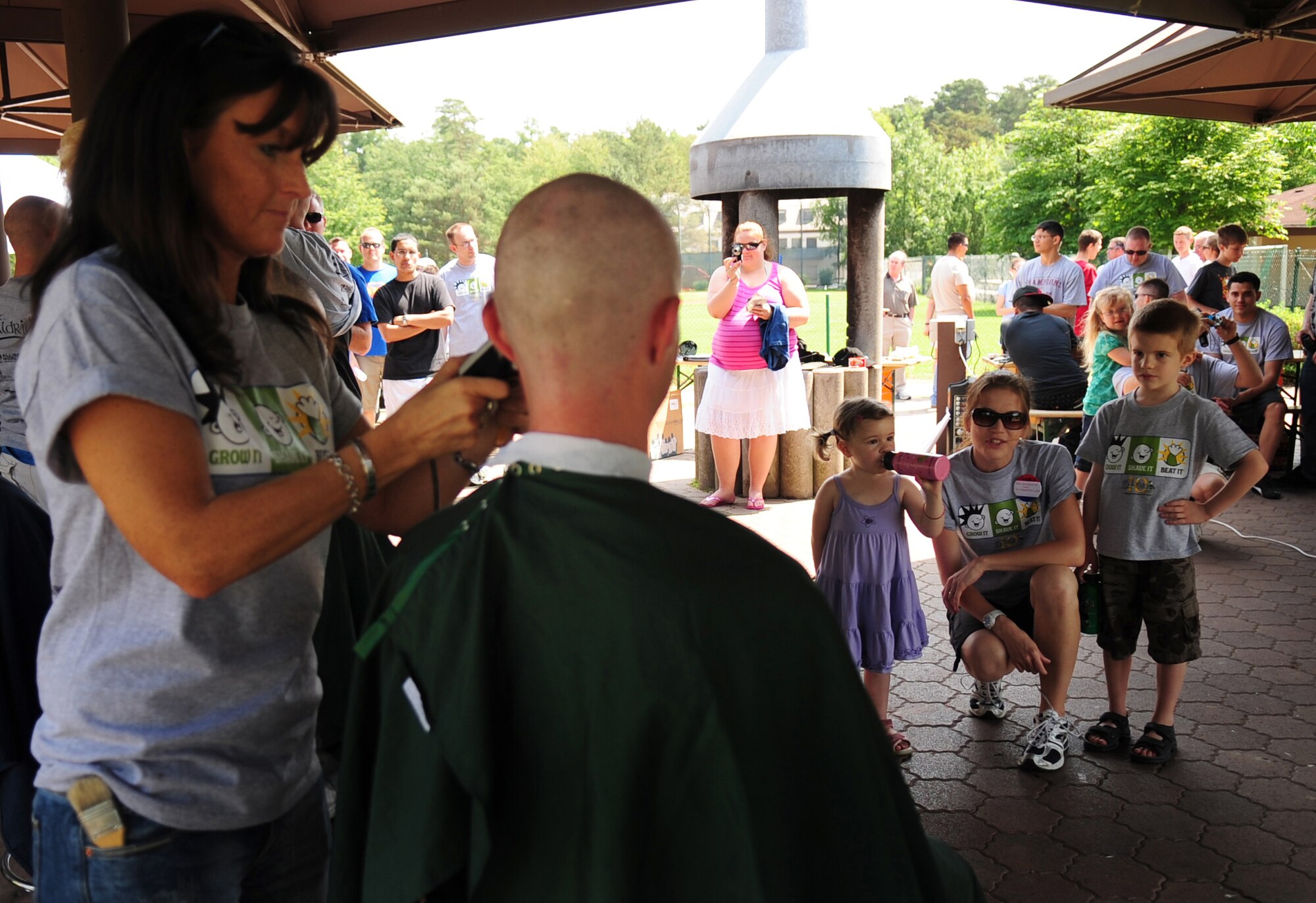 U. S. Air Force Tech. Sgt. Timothy Beardsley 86th Maintenance Squadron, has his head shaved as his daughter Josie, wife Heike and son Sam look on. Tech. Sgt Beardsley and his wife Heike organized the first St. Baldrick's event held on Ramstein Air Base Germany, June 26, 2010, in 3-year-old Josie's honor. Josie was diagnosed with Leukemia two years ago. The St. Baldrick's Foundation is an organization that tasks volunteers with getting sponsored to have their heads shaved as a demonstration of their camaraderie to children that have been diagnosed with cancer. This is the 1st ever St. Baldrick's event held on Ramstein AB. (U.S. Air Force photo by Staff Sgt. Jocelyn Rich)