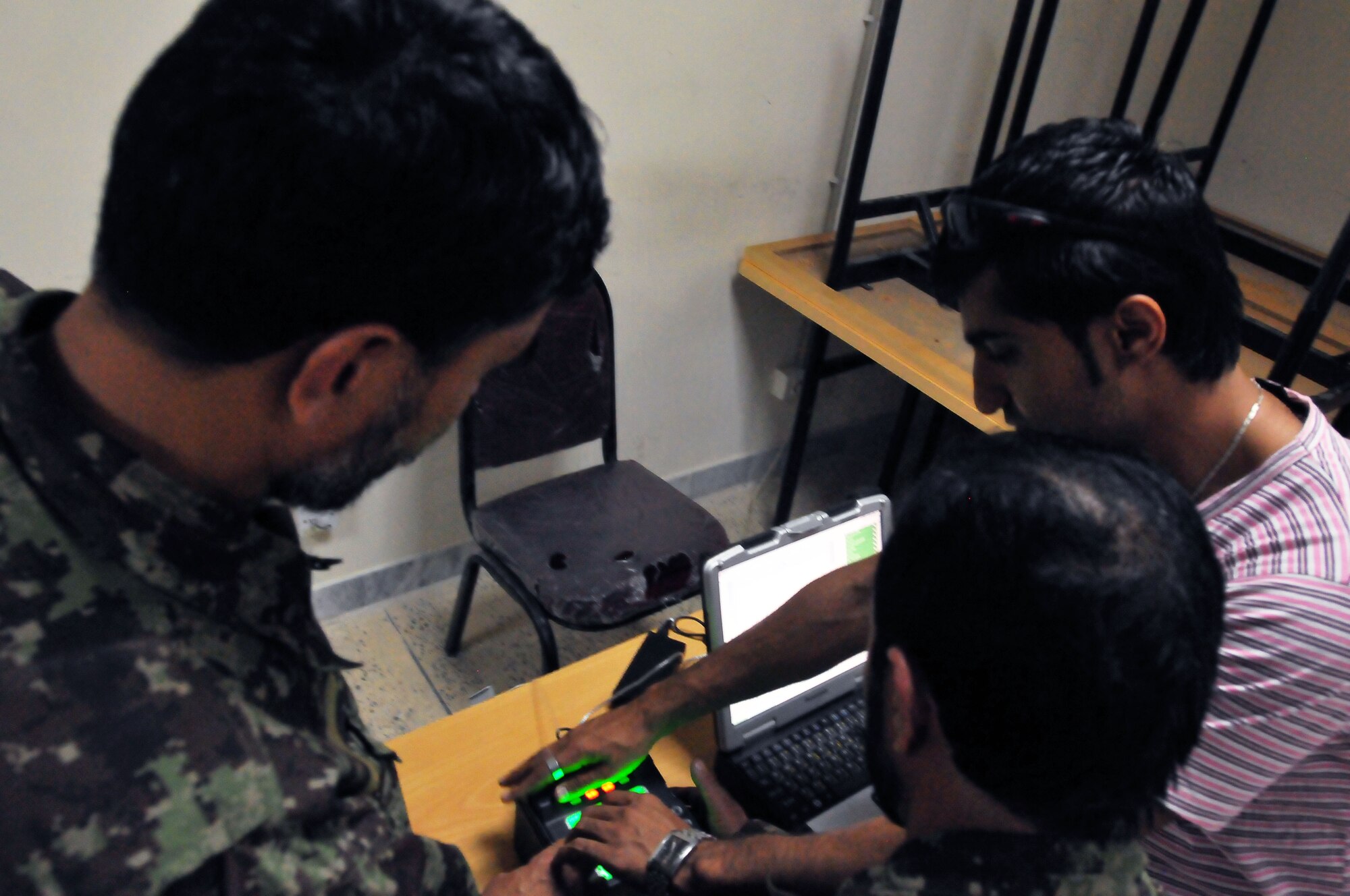 1006-N-6031Q-001 KABUL, Afghanistan -- Soldiers from the Afghan National Air Force participate in biometric data collection of their personal history, iris scan, thumb print, and urinalysis under a new accountability program in the Afghan Air Force. (US Navy photo by Mass Communication Specialist 2nd Class David Quillen/ RELEASED). 
