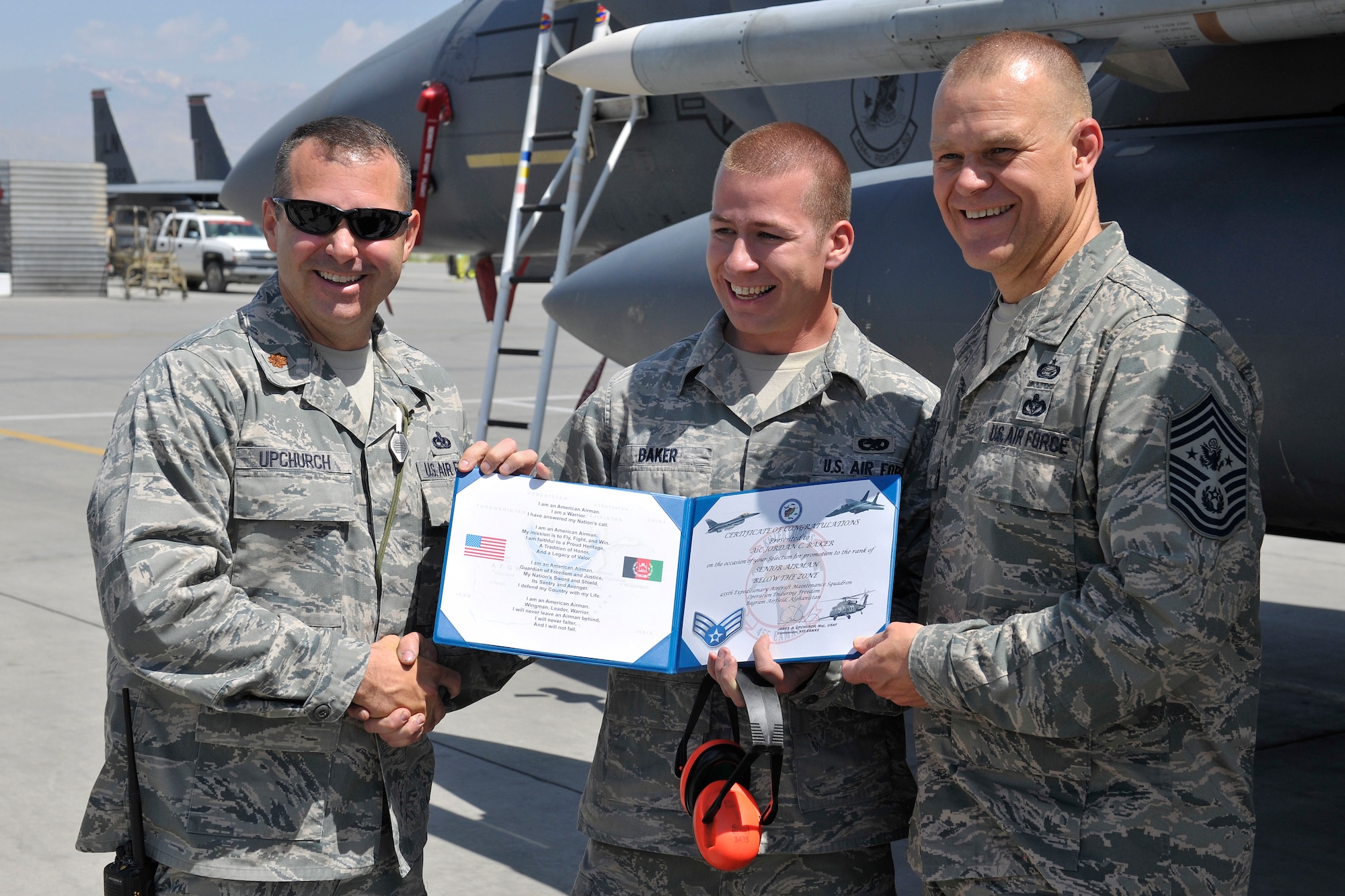 Maj. James Upchurch and Chief Master Sergeant of the Air Force James A. Roy congratulate Airman 1st Class Jordan Baker on his Below the Zone promotion to Senior Airman at Bagram Airfield, Afghanistan, June 25th 2010. Airman Baker is an F-15E Strike Eagle crew chief assigned to the 455th Expeditionary Maintenance Group and is a native of Adair, Kentucky. (U.S. Air Force Photo/Staff Sgt. Christopher Boitz)