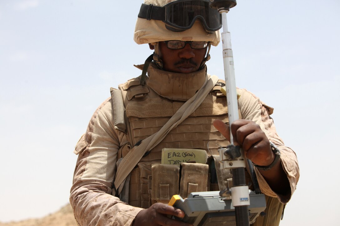 Petty Officer 2nd Class Jeremy A. Davis, 26, from Bronx, N.Y., engineering aide with Naval Mobile Construction Battalion 5, records the level of the ground during a bridge construction project in northern Marjah, Helmand Province, Afghanistan, June 26. Marines and sailors prepared the site before soldiers came in and laid down the bridge.