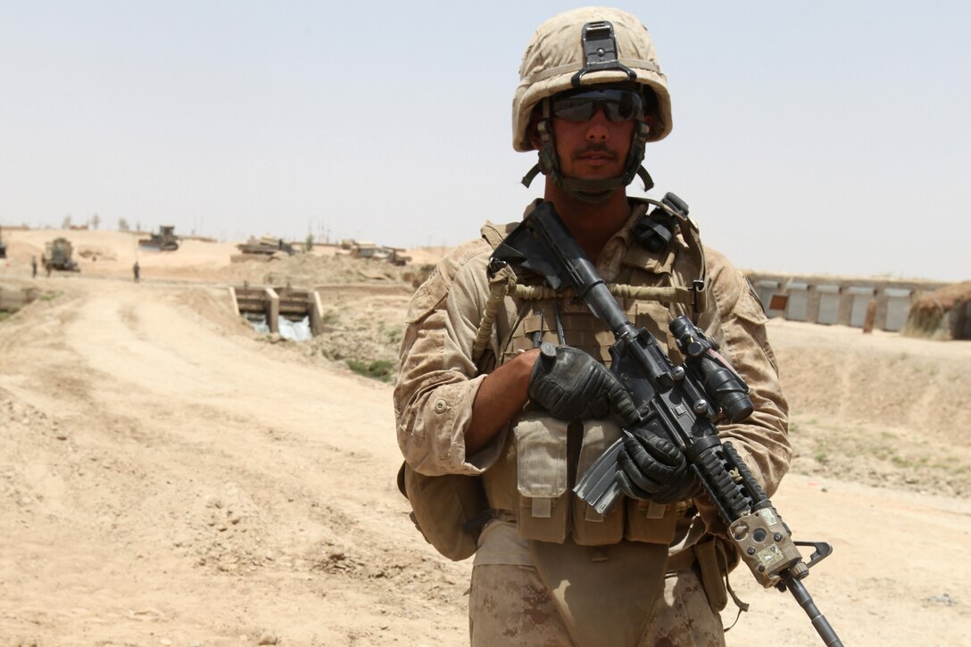 Lance Cpl. Alex L. Dore, 22, from Muskegon, Mich., security personnel with Security Platoon, 9th Engineer Support Battalion, 1st Marine Logistics Group (Forward), posts security at the site of a bridge construction project in northern Marjah, Helmand Province, Afghanistan, June 26. Curious Afghan villagers often approached to watch as Marines, soldiers and sailors constructed a bridge near their village.