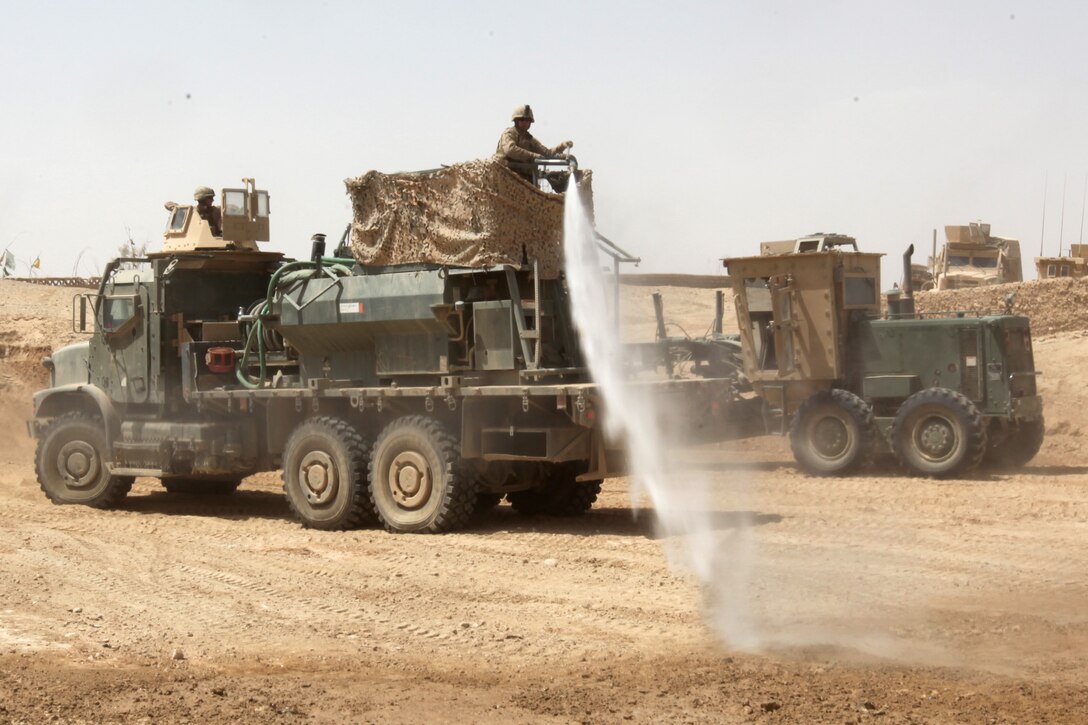 Lance Cpl. Clinc W. Nikolaus, 26, from Castle Rock, Wash., heavy equipment operator with 9th Engineer Support Battalion, 1st Marine Logistics Group (Forward), sprays water with a hydro seeder to wet the ground during a bridge construction project in northern Marjah, Helmand Province, Afghanistan, June 26. Marines of 9th ESB supported the mission by assisting sailors and soldiers with the bridge’s construction, as well as providing security for the site.