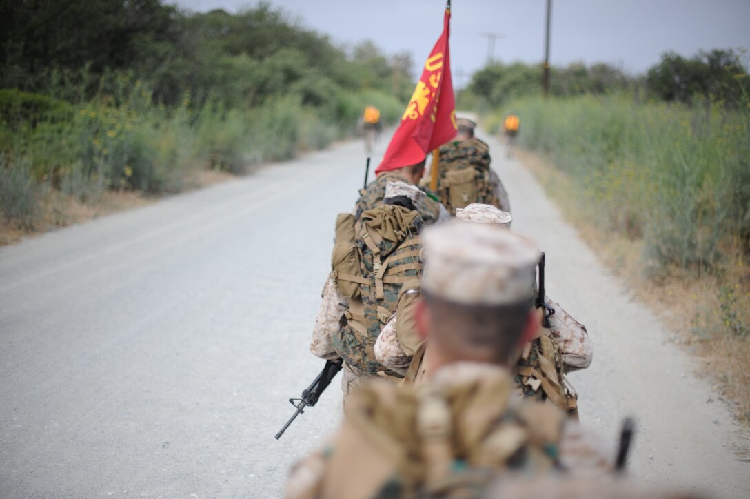 Marines, loaded with packs and weapons, stay aligned in formation while hiking at the Edson Range Complex here June 25. The six-mile hike was the 11th Marine Expeditionary Unit's first since returning from a sea deployment in April.