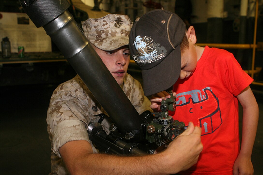 -Sergeant Jeremy Leaders, an 81mm mortar squad leader from Weapons Company, 3rd Battalion, 2nd Marine Regiment, demonstrates the features of the M252 81mm mortar.  Marines manned static displays, attended receptions and marched in parades in celebration of 100 years of service of the Canadian Navy.  The Canadian Naval Centennial went from June 25th through July 2nd.