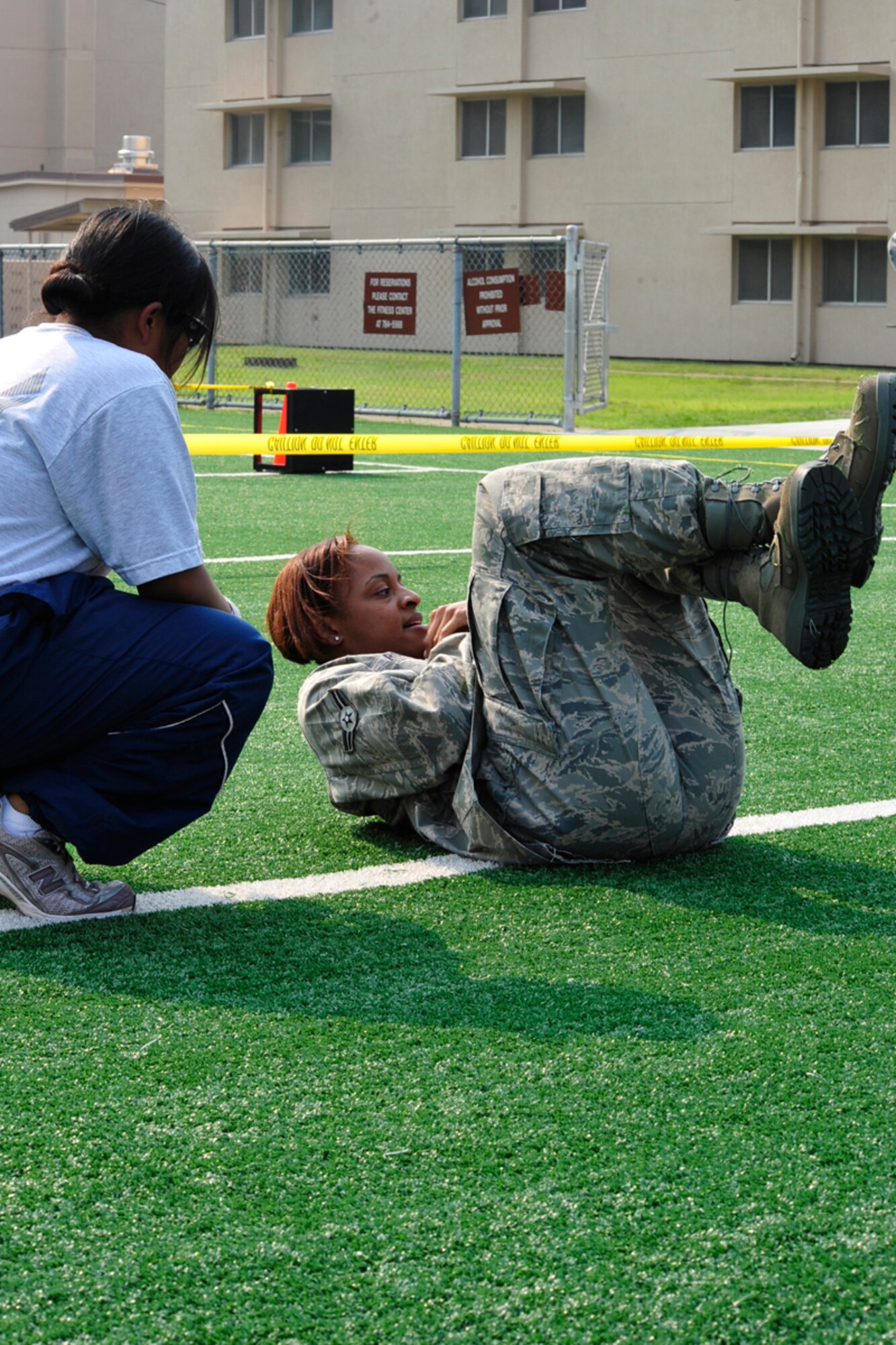 Airman 1st Class Teneil Roman, 51st Operation Support Squadron, completes crunches as a monitor keeps count during a Warrior Challenge competition, put on by the Osan Fitness Center. Throughout the competition four teams were timed as they completed several physical tasks. The team with the fastest time won trophies for each of its members. (U.S. Air Force photo/ Staff Sgt. Eunique Stevens)
