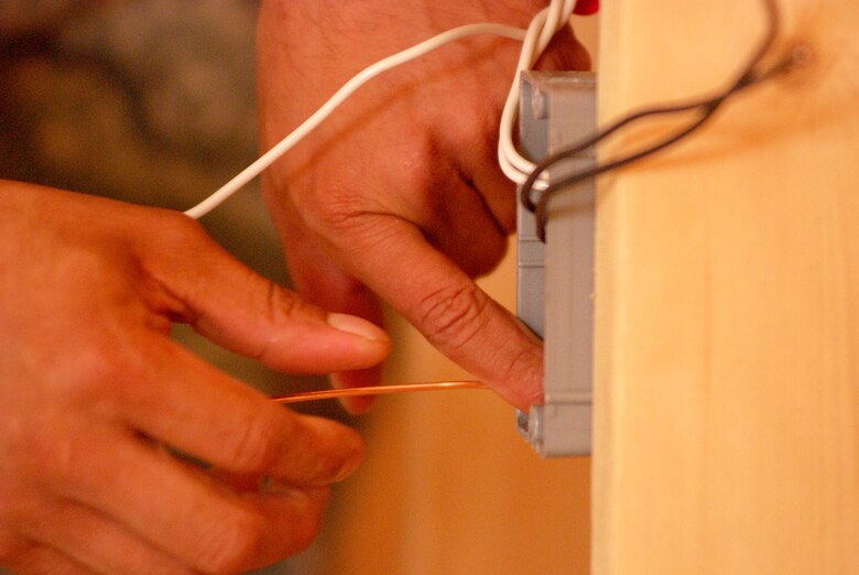 Members of the 433rd Civil Engineering Squadron conduct a humanitarian mission in the Red Lake Indian Reservation for the Red Lake band of Chippewa Indians, just outside of Bemidji, Minnesota. Staff Sgt. David Bustos wires a box which will hold an electrical outlet in what will be a bedroom wall. (U.S. Air Force photo/Airman 1st Class Brian McGloin)