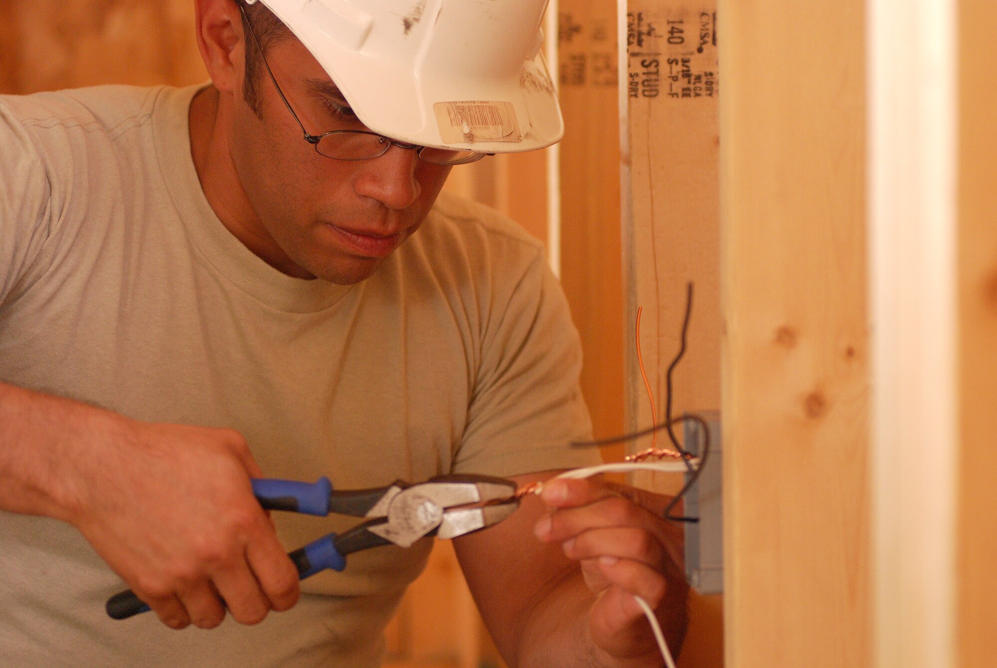 Members of the 433rd Civil Engineering Squadron conduct a humanitarian mission in the Red Lake Indian Reservation for the Red Lake band of Chippewa Indians, just outside of Bemidji, Minnesota. Staff Sgt. David Bustos wires a box which will hold an electrical outlet in what will be a bedroom wall. (U.S. Air Force photo/Airman 1st Class Brian McGloin)