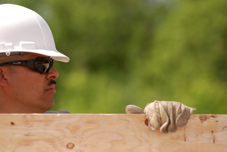 Members of the 433rd Civil Engineering Squadron conduct a humanitarian mission in the Red Lake Indian Reservation for the Red Lake band of Chippewa Indians, just outside of Bemidji, Minnesota. Tech. Sgt. Frank Mora, 433rd CES, carries a sheet of plywood which will be used for the subfloor in a home. (U.S. Air Force photo/Airman 1st Class Brian McGloin)