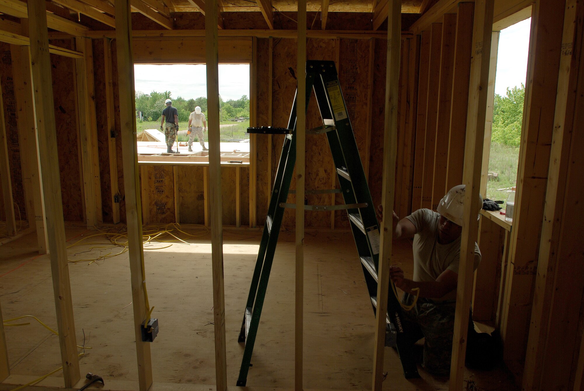 Members of the 433rd Civil Engineering Squadron conduct a humanitarian mission in the Red Lake Indian Reservation for the Red Lake band of Chippewa Indians, just outside of Bemidji, Minnesota. Staff Sgt. David Bustos, 433rd CES electrician, installs wires for electrical sockets and switches in what will be a bedroom. (U.S. Air Force photo/Airman 1st Class Brian McGloin)