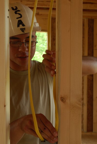 Members of the 433rd Civil Engineering Squadron conduct a humanitarian mission in the Red Lake Indian Reservation for the Red Lake band of Chippewa Indians, just outside of Bemidji, Minnesota. Senior Airman Jaime Payen, an electrician from the 433rd Civil Engineering Squadron, installs wire for electricity for lights and electrical sockets.(U.S. Air Force photo/Airman 1st Class Brian McGloin)