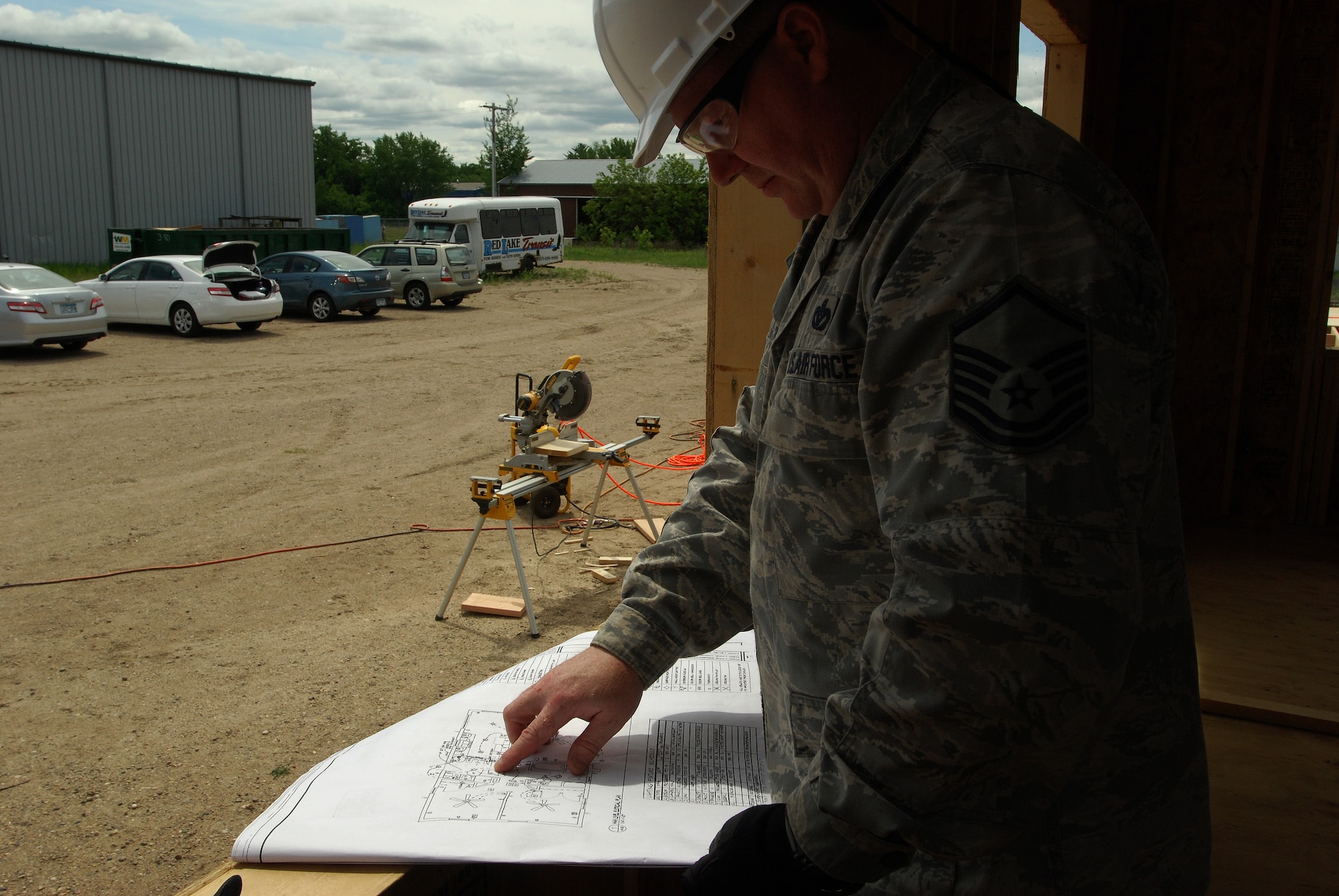 Members of the 433rd Civil Engineering Squadron conduct a humanitarian mission in the Red Lake Indian Reservation for the Red Lake band of Chippewa Indians, just outside of Bemidji, Minnesota. Master Sgt. Curtis Wilson, 433rd Civil Engineering Squadron electician, reviews plans of a house under construction.(U.S. Air Force photo/Airman 1st Class Brian McGloin)