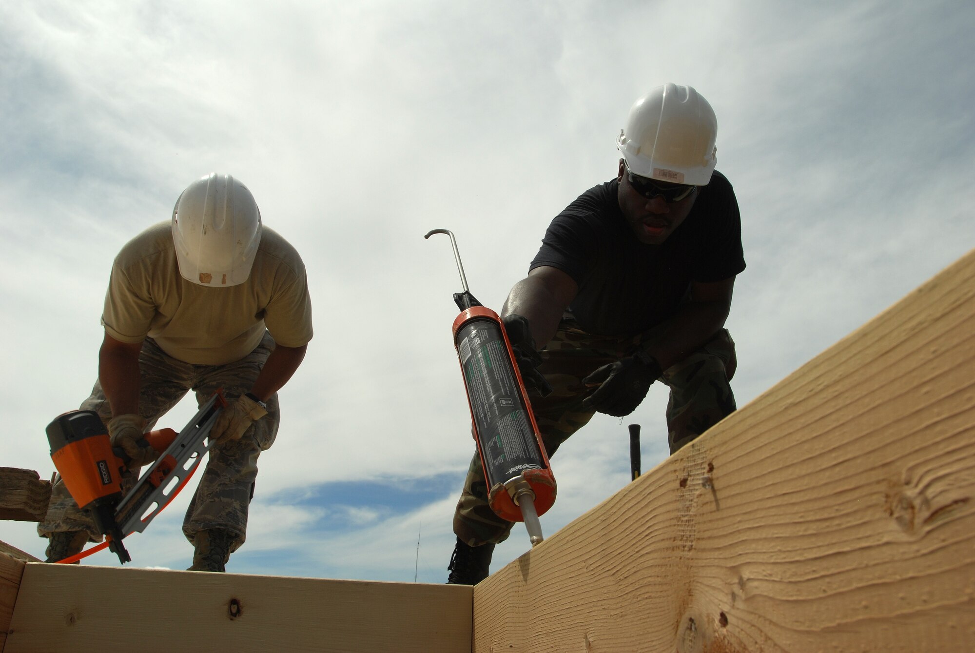 Members of the 433rd Civil Engineering Squadron conduct a humanitarian mission in the Red Lake Indian Reservation for the Red Lake band of Chippewa Indians, just outside of Bemidji, Minnesota. Tech. Sgt. Frank Mora nails a plywood subfloor down while Tech. Sgt. Mark Johnson applied construction adhesive for the next sheet.(U.S. Air Force photo/Airman 1st Class Brian McGloin)