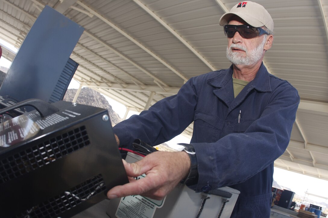 Carl Atchley, a hazardous material identifier with the Combat Center's Hazardous Material Management Branch, inspects a battery's charging status Tuesday at the branch's area of operations here. Atchley is one of 11 on staff who manage the installation's hazardous waste.