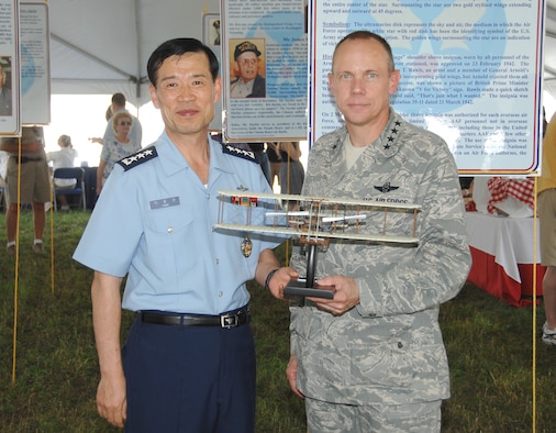 Gen. Don Hoffman, Air Force Materiel Command commander, presents a Wright Flyer to Lt. Gen. Jongheon Park, commander of the Education and Training Command for the Republic of Korea Air Force, at the AFMC Freedom's Call Tattoo June 25, 2010, at Wright-Patterson Air Force Base, Ohio. The theme of the sixth annual event was 'Reflections on 60 Years' and honored Korean War vets on the 60th anniversary of the Korean War's start. (U.S. Air Force photo/Ben Strasser) 