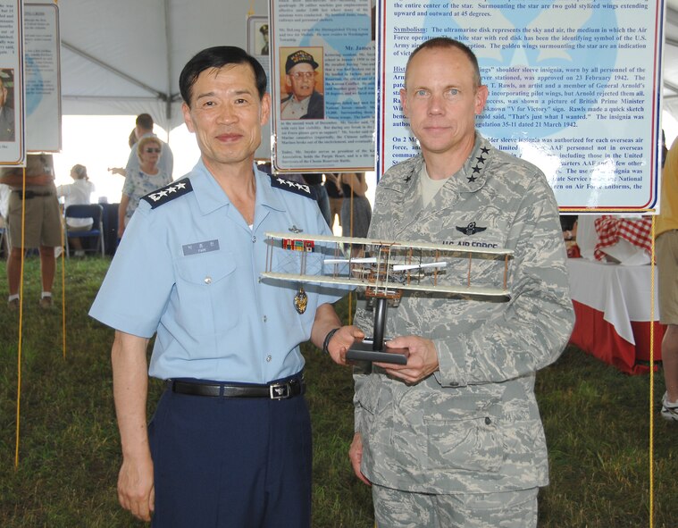 Gen. Don Hoffman, Air Force Materiel Command commander, presents a Wright Flyer to Lt. Gen. Jongheon Park, commander of the Education and Training Command for the Republic of Korea Air Force, at the AFMC Freedom's Call Tattoo June 25, 2010, at Wright-Patterson Air Force Base, Ohio. The theme of the sixth annual event was 'Reflections on 60 Years' and honored Korean War vets on the 60th anniversary of the Korean War's start. (U.S. Air Force photo/Ben Strasser) 