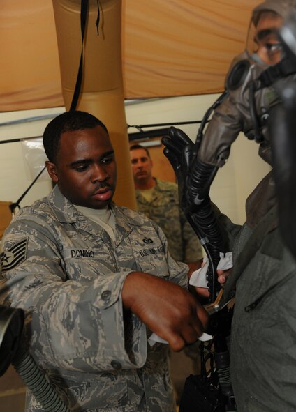 MOODY AIR FORCE BASE, Ga. -- Tech. Sgt. Burnell Domino, 366th Operation Support Squadron aircrew flight equipment NCO-in charge from Mountain Home Air Force Base, Idaho, uses scissors to remove a portion of aircrew flight equipment from a member during a training exercise here June 16. During some stages, the contaminated individual is sprayed with a mixture of water and bleach solution in addition to the gradual removal of their equipment. (U.S. Air Force photo by Airman 1st Class Benjamin Wiseman/RELEASED)