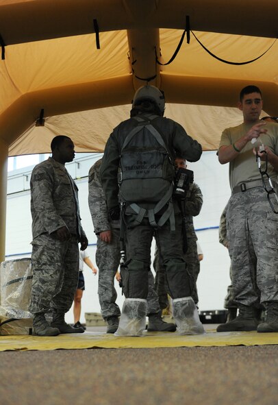 MOODY AIR FORCE BASE, Ga. -- Personnel work to remove aircrew flight equipment from Senior Airman Kyle Bumgardener, 23rd Operation Support Squadron AFE member, during a training exercise held here June 16. The Lightweight Inflatable Decontamination system has four stages that aircrew members must process through. (U.S. Air Force photo by Airman 1st Class Benjamin Wiseman/RELEASED)