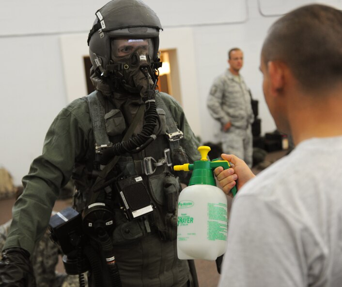 MOODY AIR FORCE BASE, Ga. -- Staff Sgt. James Pizon, 355th Operation Support Squadron aircrew flight equipment member from Davis-Monthan Air Force Base, Ariz., sprays down Senior Airman Kyle Bumgardener, 23rd Operation Support Squadron AFE member, with a bleach solution during a training exercise here June 16. Sergeant Pizon was one of many aircrew flight equipment personnel that came to Moody to participate in the training. (U.S. Air Force photo by Airman 1st Class Benjamin Wiseman/RELEASED)