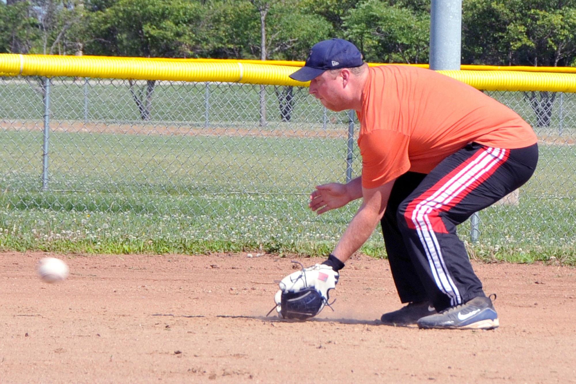 OFFUTT AIR FORCE BASE, Neb. - Roy Jacox Jr., with the 2d Systems Operations Squadron softball team, eyes a grounder at third base June 24 as he practices with the rest of the team at the softball fields on base.  The 2010 intramural softball season began June 28 with 20 teams all vying for the title of base champion. U.S. Air Force photo by Jeff W. Gates.