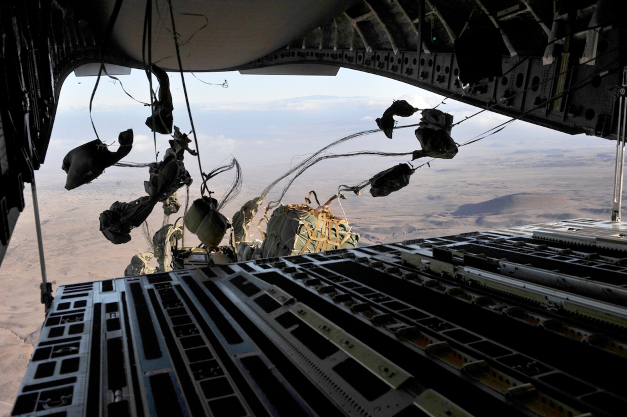 Seven container delivery system bundles containing Meals, Ready to Eat and milk are dropped from the ramp of a 535th Airlift Squadron C-17 Globemaster III to Marines from Marine Corps Base Hawaii, Kaneohe Bay, June 24, 2010, while above the Big Island of Hawaii, in support of the Rim of the Pacific exercise. (U.S. Air Force photo/Tech. Sgt. Cohen A. Young) 