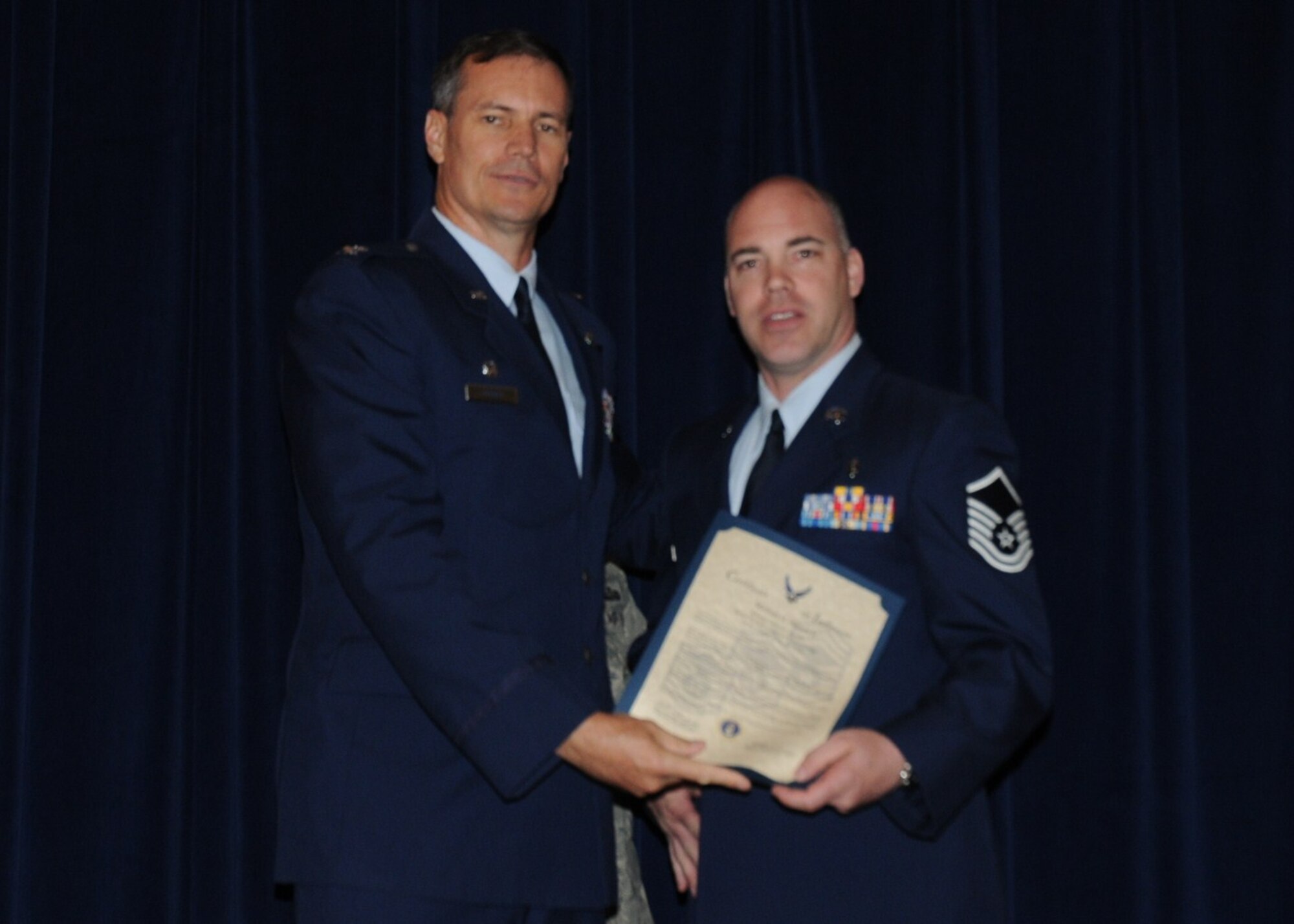 Colonel Michael Popovich, 944th Fighter Wing commander, welcomes Master Sgt. Michael Wolver Jr, 944th Aeromedical Staging Squadron, into the ranks of senior NCOs during the 944th Fighter Wing induction ceremony June 5, 2010. (U.S. Air Force photo/Staff Sgt. Denise Willhite)