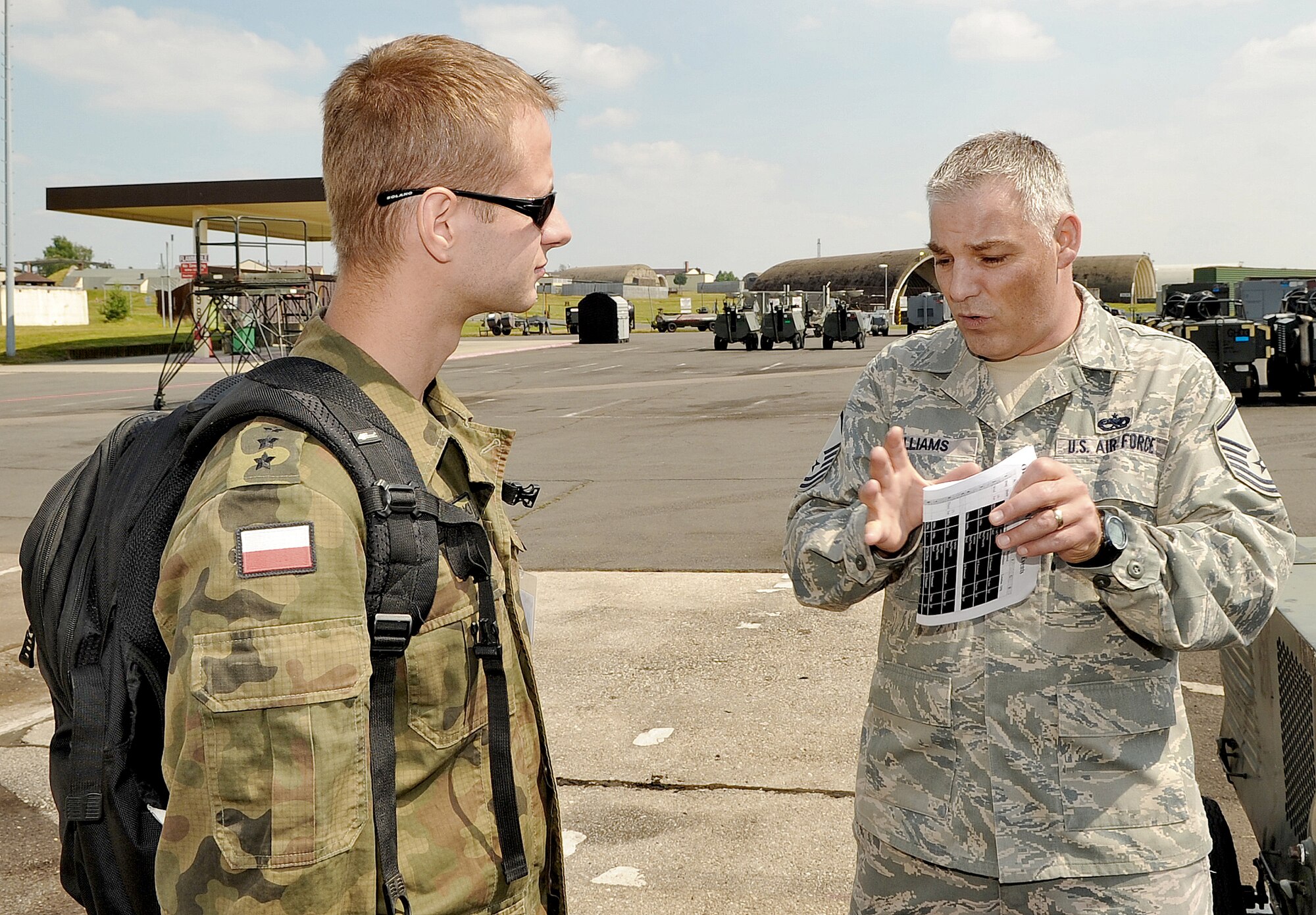 Master Sgt. Jason Williams gives a flightline tour to Polish air force Lt. Mariusz Choszczewski during a U.S. Air Forces in Europe Operational Readiness Inspection June 23, 2010 at Spangdahlem Air Base, Germany. Sergeant Williams is the 31st Maintenance Group readiness superintendent at Aviano Air Base, Italy and Lieutenant Choszczewski is assigned to the 32nd Air Tactical Base, Poland. (U.S. Air Force photo/Airman 1st Class Nick Wilson)