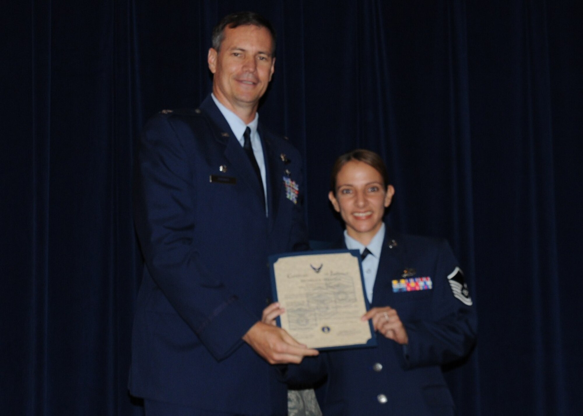 Colonel Michael Popovich, 944th Fighter Wing commander, welcomes Master Sgt. Michelle Verduzco, 944th Mission Support Group, into the ranks of senior NCOs during the 944th Fighter Wing induction ceremony June 5, 2010. (U.S. Air Force photo/Staff Sgt. Denise Willhite)