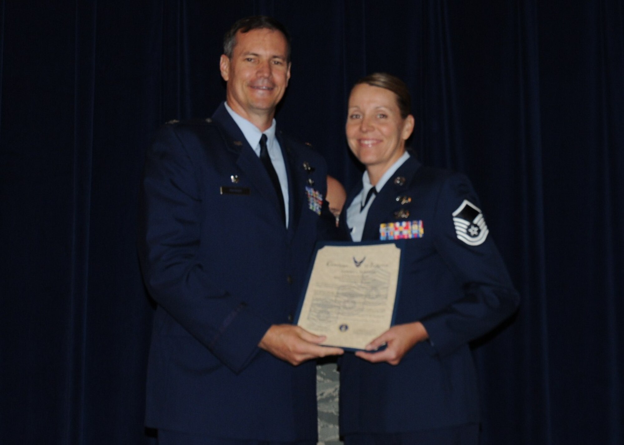 Colonel Michael Popovich, 944th Fighter Wing commander, welcomes Master Sgt. Sandra Plentzas, 944th Fighter Wing, into the ranks of senior NCOs during the 944th Fighter Wing induction ceremony June 5, 2010. (U.S. Air Force photo/Staff Sgt. Denise Willhite)