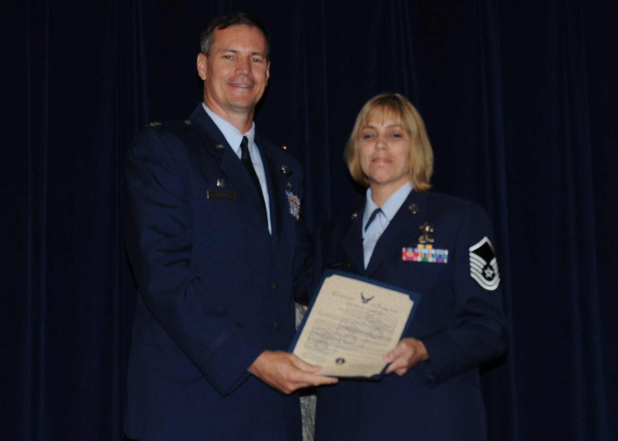 Colonel Michael Popovich, 944th Fighter Wing commander, welcomes Master Sgt. Michelle Harvey, 944th Mission Support Flight, into the ranks of senior NCOs during the 944th Fighter Wing induction ceremony June 5, 2010. (U.S. Air Force photo/Staff Sgt. Denise Willhite)