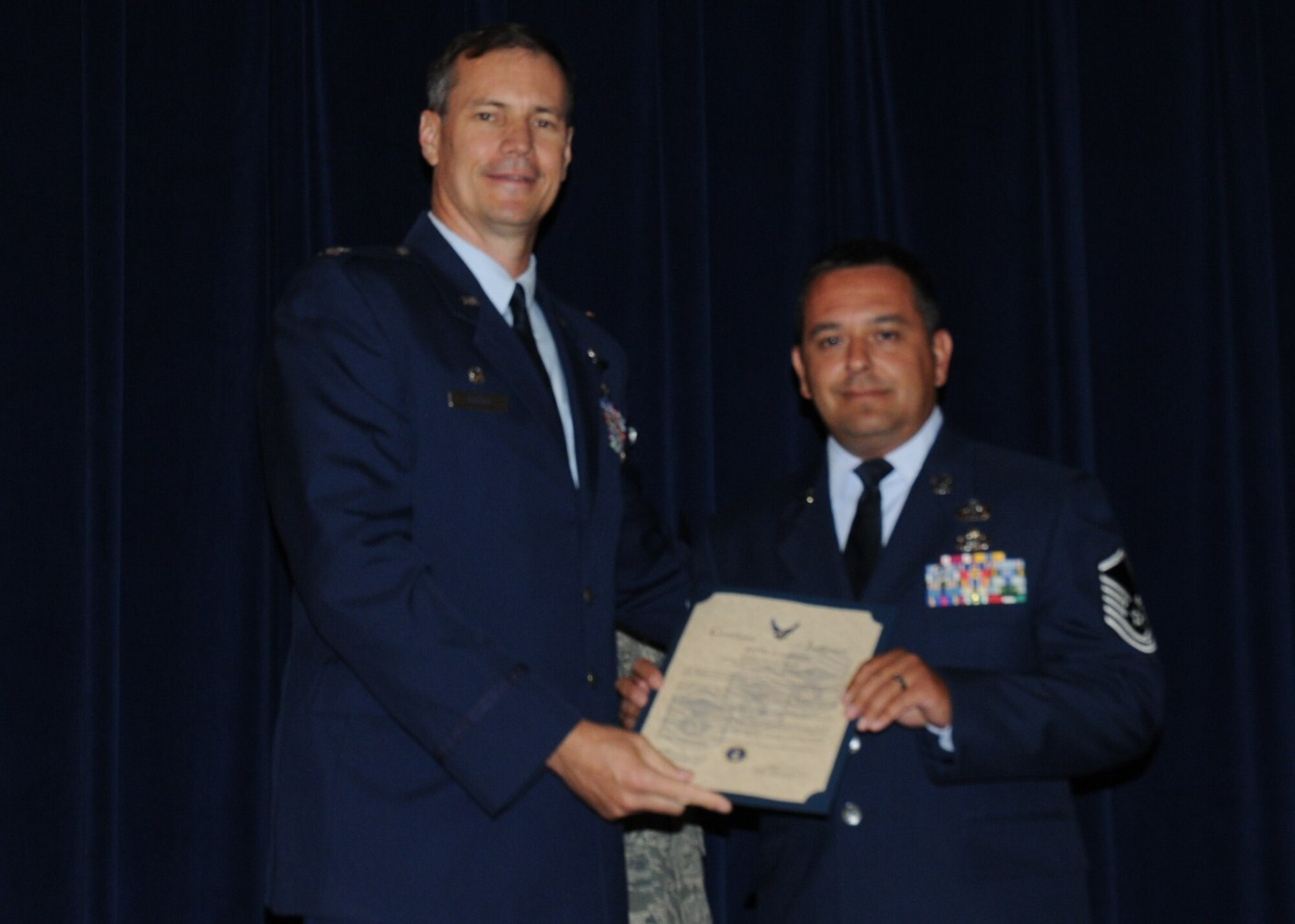 Colonel Michael Popovich, 944th Fighter Wing commander, welcomes Master Sgt. Keith Gabriel, 944th Civil Engineer Squadron, into the ranks of senior NCOs during the 944th Fighter Wing induction ceremony June 5, 2010. (U.S. Air Force photo/Staff Sgt. Denise Willhite)
