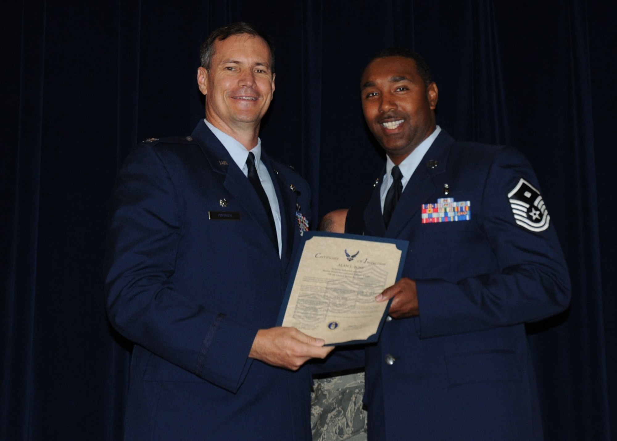 Colonel Michael Popovich, 944th Fighter Wing commander, welcomes Master Sgt. Alan Boss, 944th Security Forces Squadron, into the ranks of senior NCOs during the 944th Fighter Wing induction ceremony June 5, 2010. (U.S. Air Force photo/Staff Sgt. Denise Willhite)
