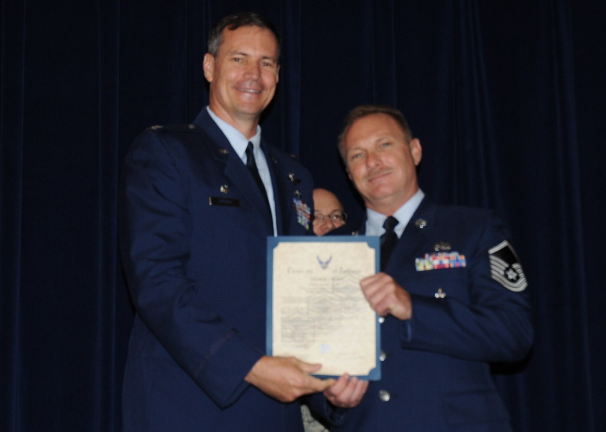 Colonel Michael Popovich, 944th Fighter Wing commander, welcomes Master Sgt. Thomas Bond, 944th Fighter Wing, into the ranks of senior NCOs during the 944th Fighter Wing induction ceremony June 5, 2010. (U.S. Air Force photo/Staff Sgt. Denise Willhite)