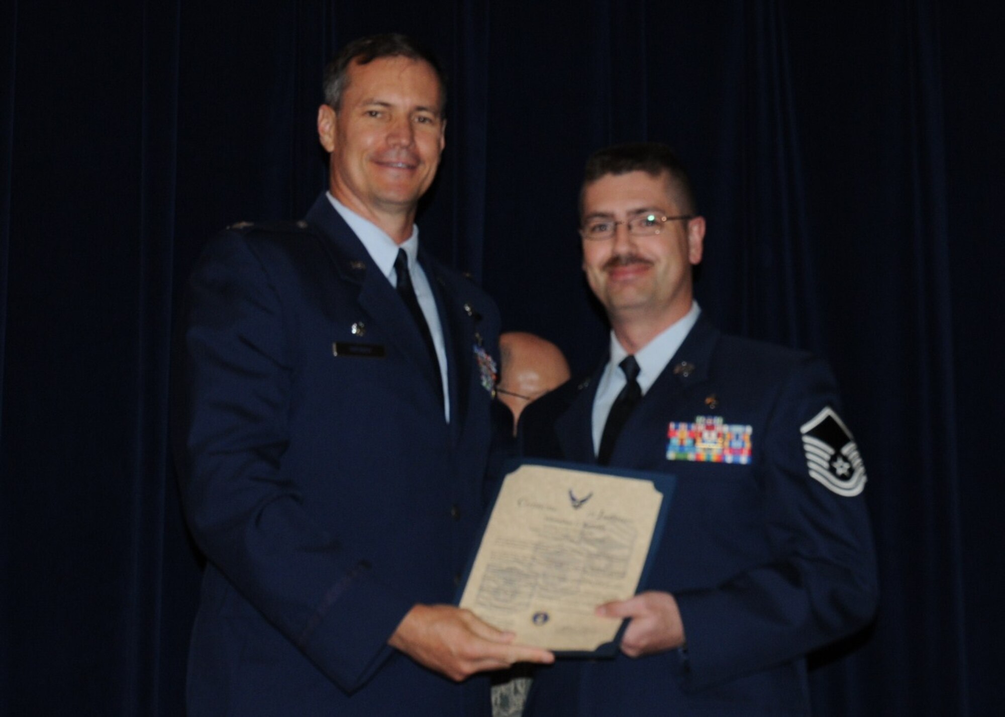 Colonel Michael Popovich, 944th Fighter Wing commander, welcomes Master Sgt. Johnathan Bartram, 944th Aeromedical Staging Squadron, into the ranks of senior NCOs during the 944th Fighter Wing induction ceremony June 5, 2010. (U.S. Air Force photo/Staff Sgt. Denise Willhite)