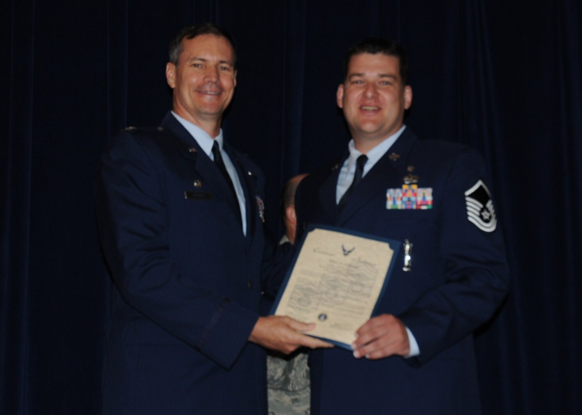 Colonel Michael Popovich, 944th Fighter Wing commander, welcomes Master Sgt. Jeffery Amburgey, 944th Medical Squadron, into the ranks of senior NCOs during the 944th Fighter Wing induction ceremony June 5, 2010. (U.S. Air Force photo/Staff Sgt. Denise Willhite)