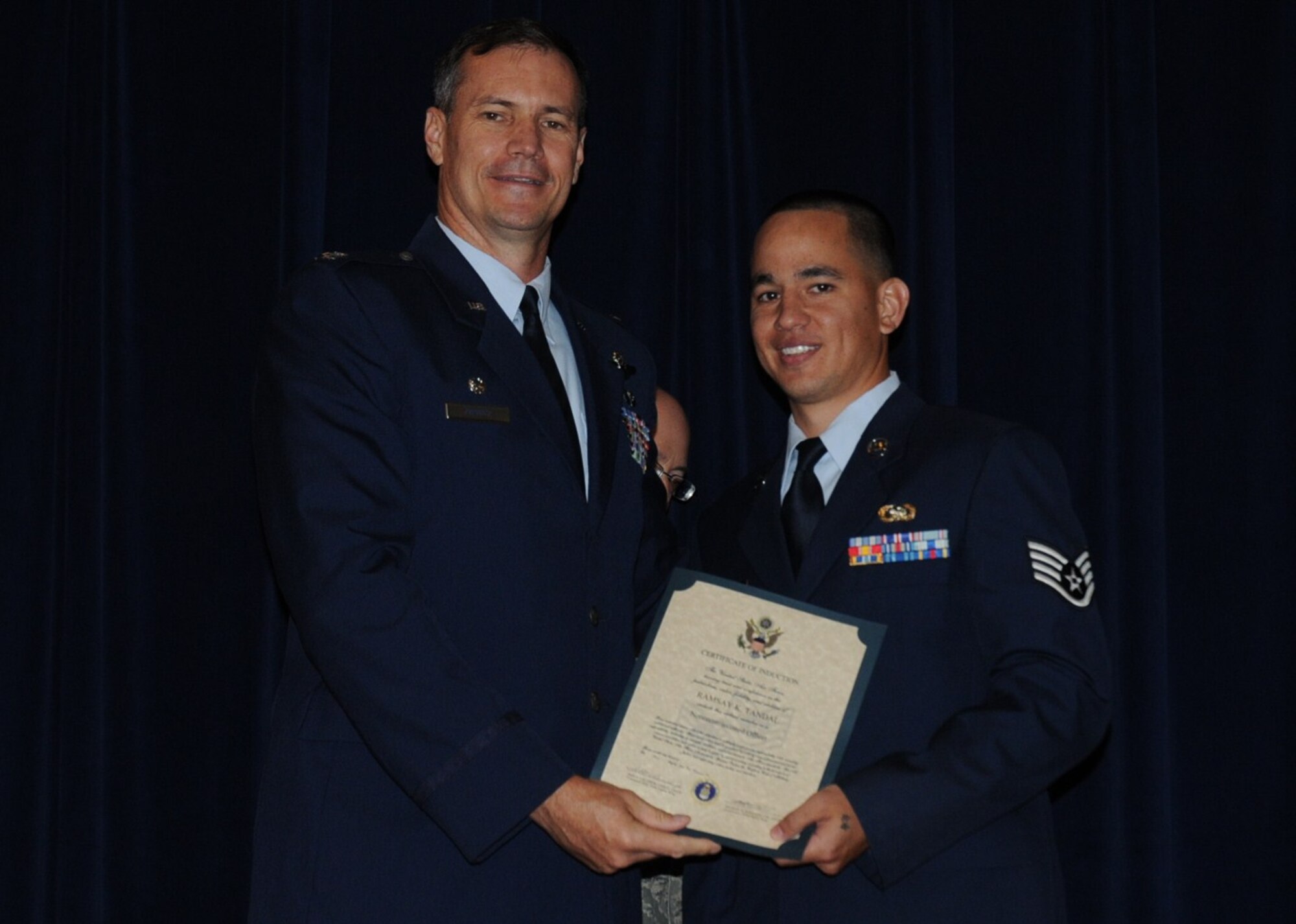 Colonel Michael Popovich, 944th Fighter Wing commander, welcomes Staff Sgt. Ramsay Tandal, 944th Logistics Readiness Squadron, into the rank of NCO during the 944th Fighter Wing induction ceremony June 5, 2010. (U.S. Air Force photo/Staff Sgt. Denise Willhite)