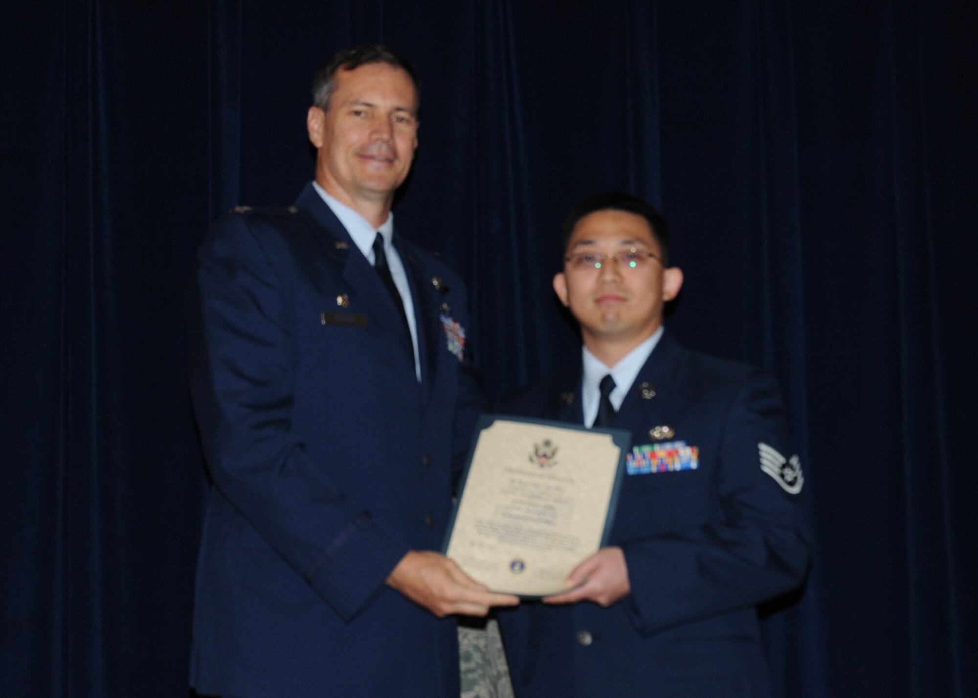 Colonel Michael Popovich, 944th Fighter Wing commander, welcomes Staff Sgt. Jung Shin, 944th Civil Engineer Squadron, into the rank of NCO during the 944th Fighter Wing induction ceremony June 5, 2010. (U.S. Air Force photo/Staff Sgt. Denise Willhite)