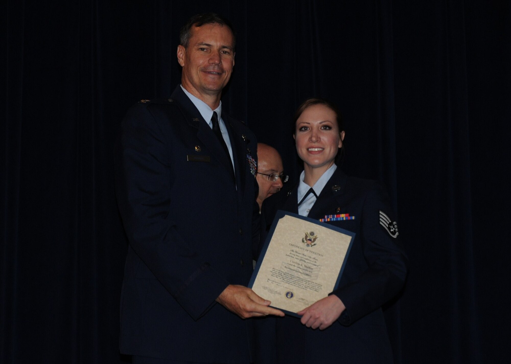 Colonel Michael Popovich, 944th Fighter Wing commander, welcomes Staff Sgt. Caroline Shelton, 944th Aeromedical Staging Squadron, into the rank of NCO during the 944th Fighter Wing induction ceremony June 5, 2010. (U.S. Air Force photo/Staff Sgt. Denise Willhite)