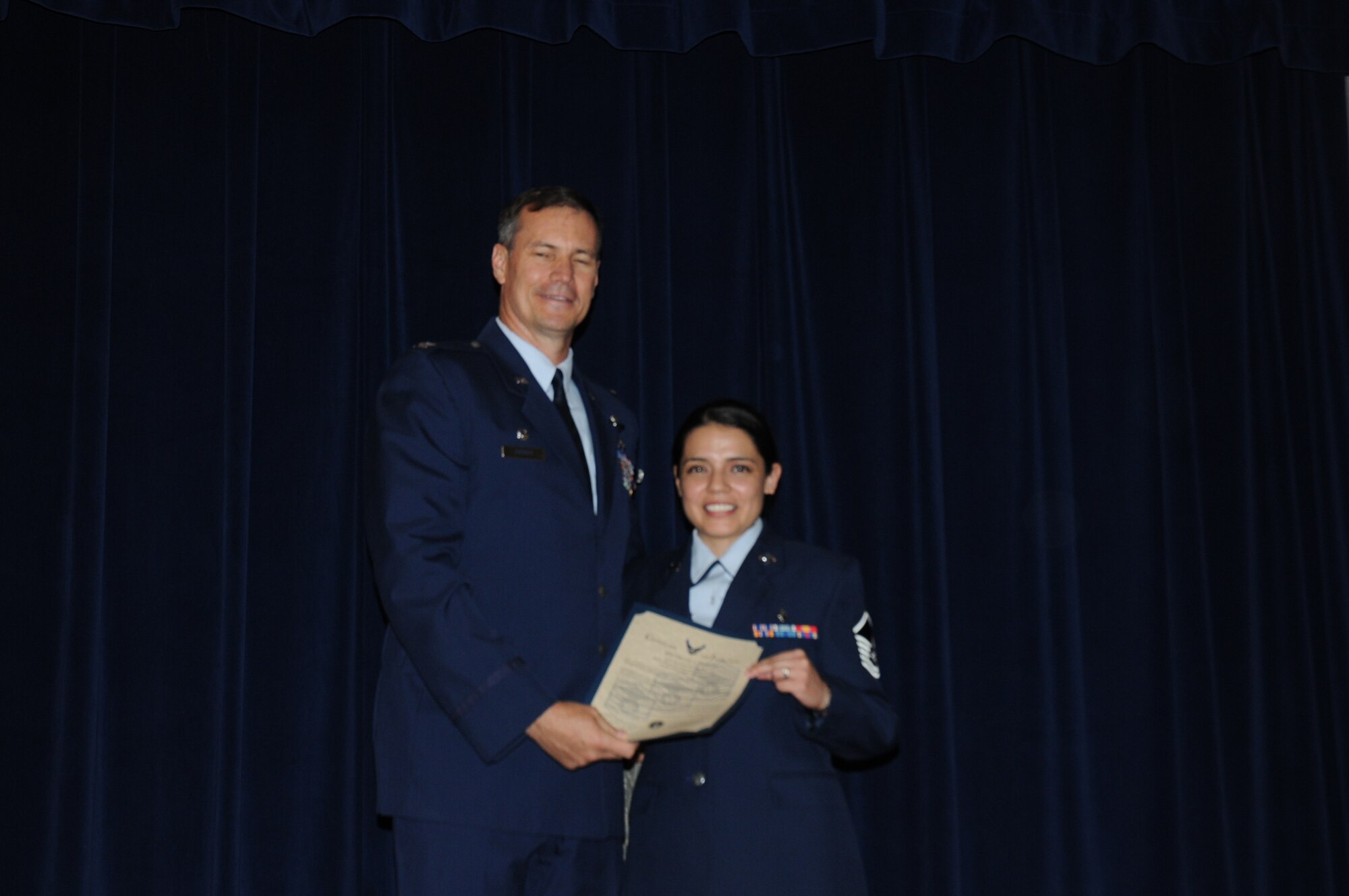 Colonel Michael Popovich, 944th Fighter Wing commander, welcomes Master Sgt. Zelmira Farmer, 944th Medical Squadron, into the ranks of senior NCOs during the 944th Fighter Wing induction ceremony June 5, 2010. (U.S. Air Force photo/Staff Sgt. Denise Willhite)
