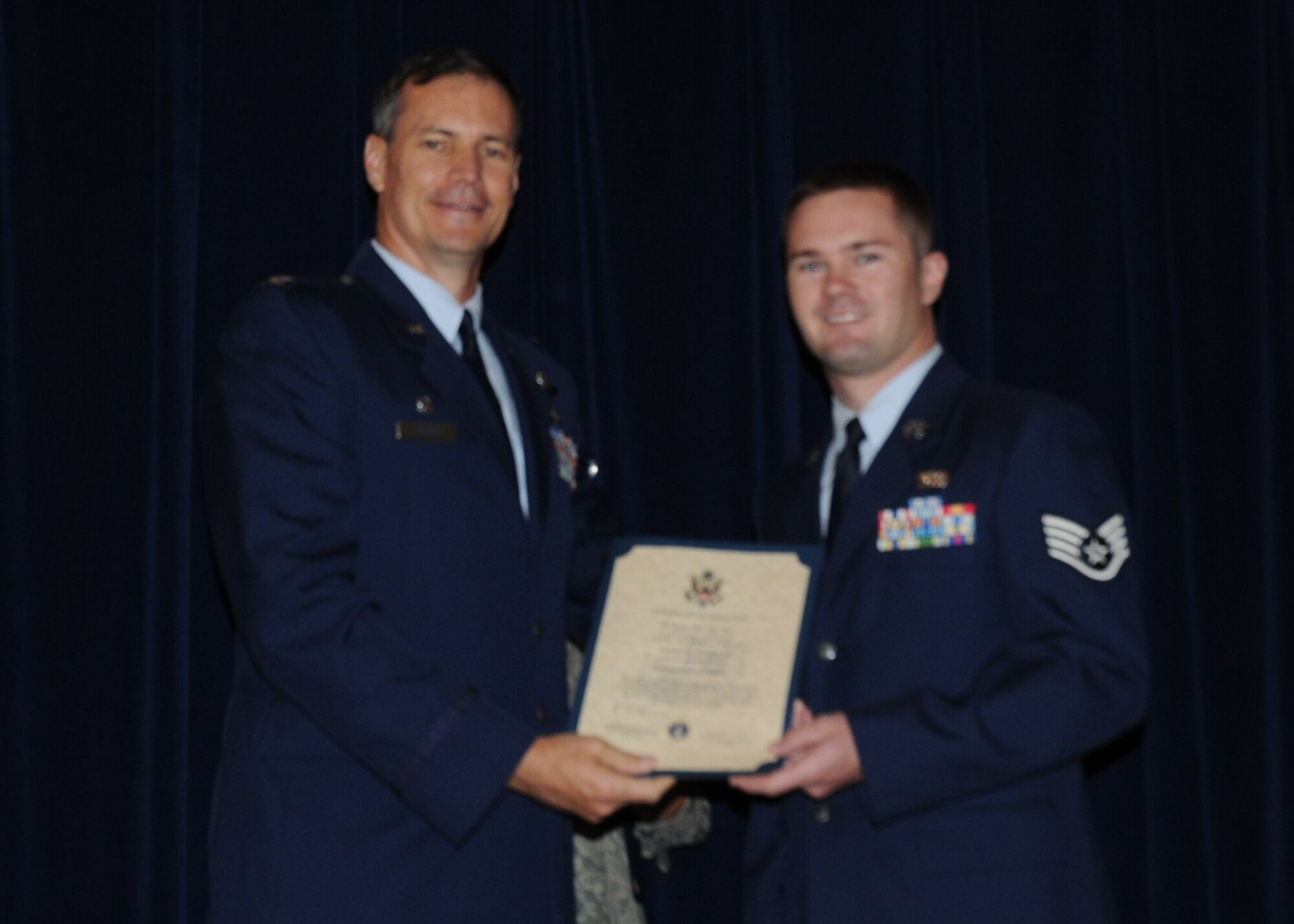 Colonel Michael Popovich, 944th Fighter Wing commander, welcomes Staff Sgt. James Schults, 944th Civil Engineer Squadron, into the rank of NCO during the 944th Fighter Wing induction ceremony June 5, 2010. (U.S. Air Force photo/Staff Sgt. Denise Willhite)