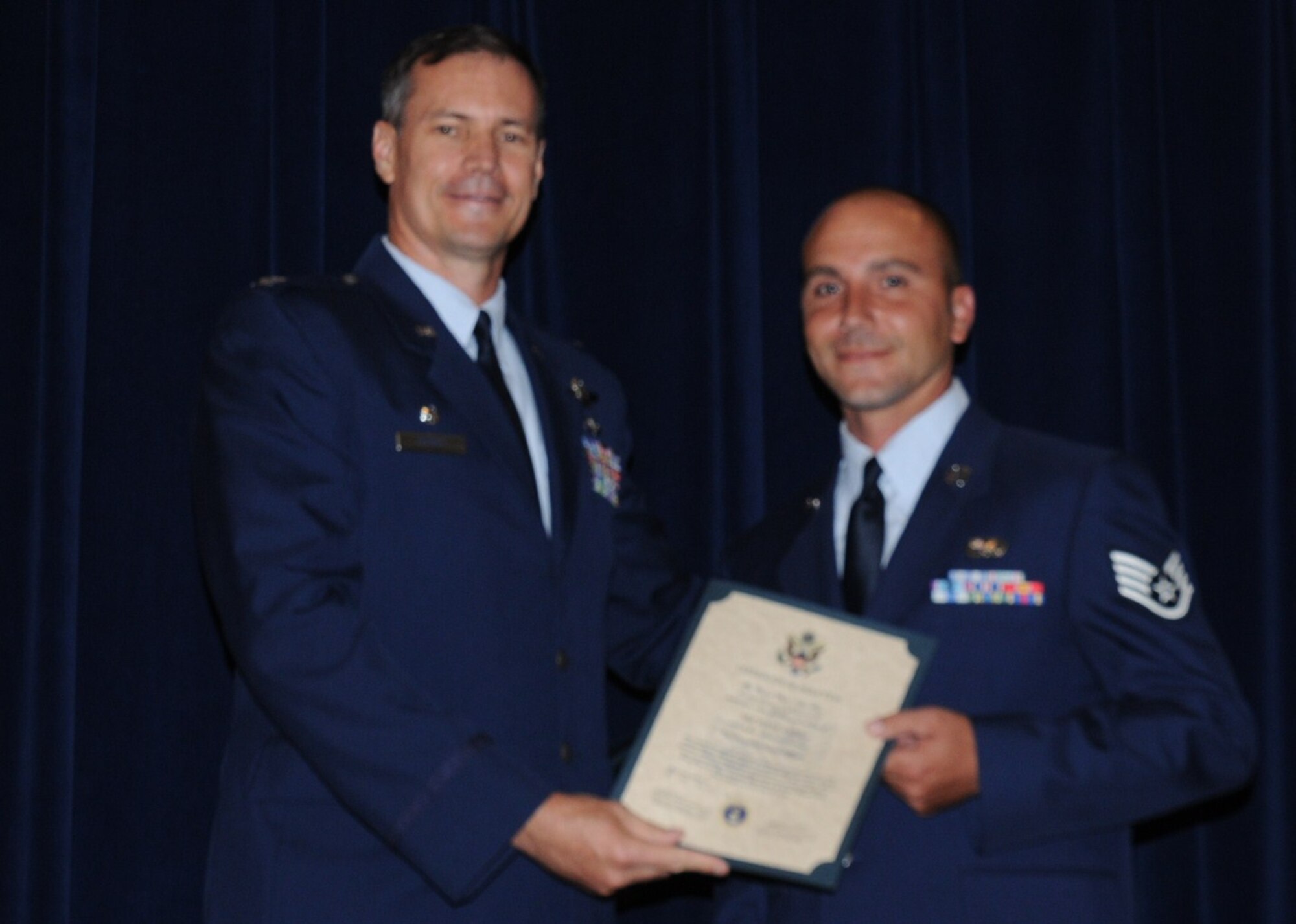 Colonel Michael Popovich, 944th Fighter Wing commander, welcomes Staff Sgt. Michael Orso, 944th Logistics Readiness Squadron, into the rank of NCO during the 944th Fighter Wing induction ceremony June 5, 2010. (U.S. Air Force photo/Staff Sgt. Denise Willhite)