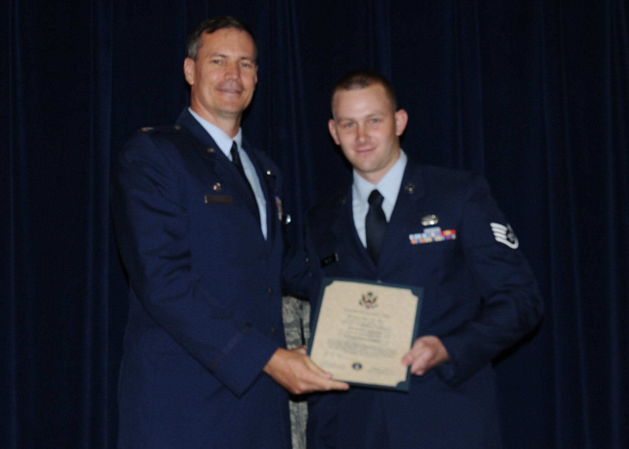 Colonel Michael Popovich, 944th Fighter Wing commander, welcomes Staff Sgt. Brian Miller, 944th Logistics Readiness Squadron, into the rank of NCO during the 944th Fighter Wing induction ceremony June 5, 2010. (U.S. Air Force photo/Staff Sgt. Denise Willhite)