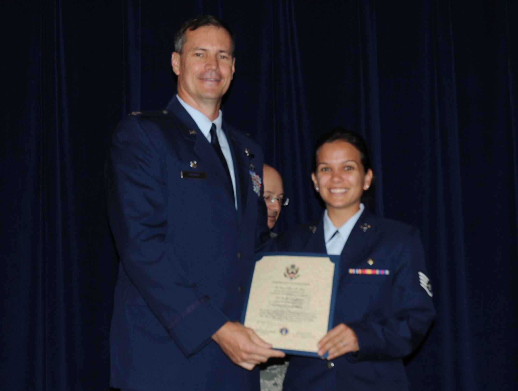 Colonel Michael Popovich, 944th Fighter Wing commander, welcomes Staff Sgt. Nicole Lougheed, 944th Aeromedical Staging Squadron, into the rank of NCO during the 944th Fighter Wing induction ceremony June 5, 2010. (U.S. Air Force photo/Staff Sgt. Denise Willhite)