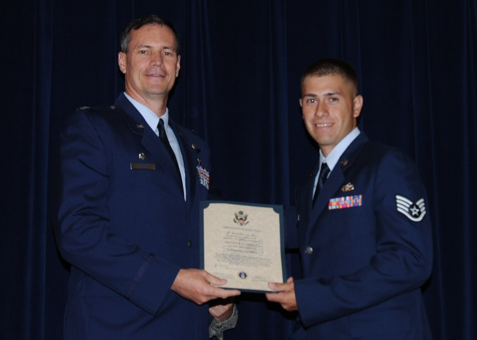 Colonel Michael Popovich, 944th Fighter Wing commander, welcomes Staff Sgt. Fredrick Arreola, 944th Civil Engineer Squadron, into the rank of NCO during the 944th Fighter Wing induction ceremony June 5, 2010. (U.S. Air Force photo/Staff Sgt. Denise Willhite)