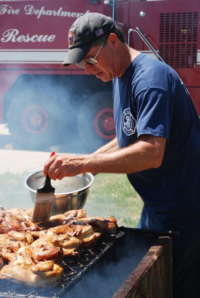 Fire Captain John Peters marinates chicken as part of the Westover Fire Departments cookout fundraiser on June 25.  The firefighters, who are members of the Federal Firefighters Benevolent Association, raise money year-round for Westover members in need and for the burn unit at the Shriner's Hospital for Children in Boston.  The cookout raised about $1000.